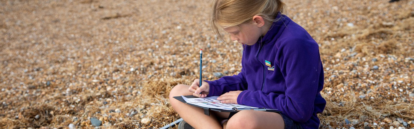 Student filling in the litter survey during the Great British Beach Clean on Hove Beach Billy Barraclough